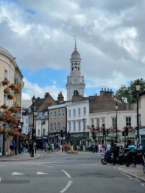 A vibrant street scene in Angel, N1, showcasing a floral arrangement delivered by floristislington.co.uk in the foreground. The bouquet features a mix of fresh, colorful flowers including pink roses,